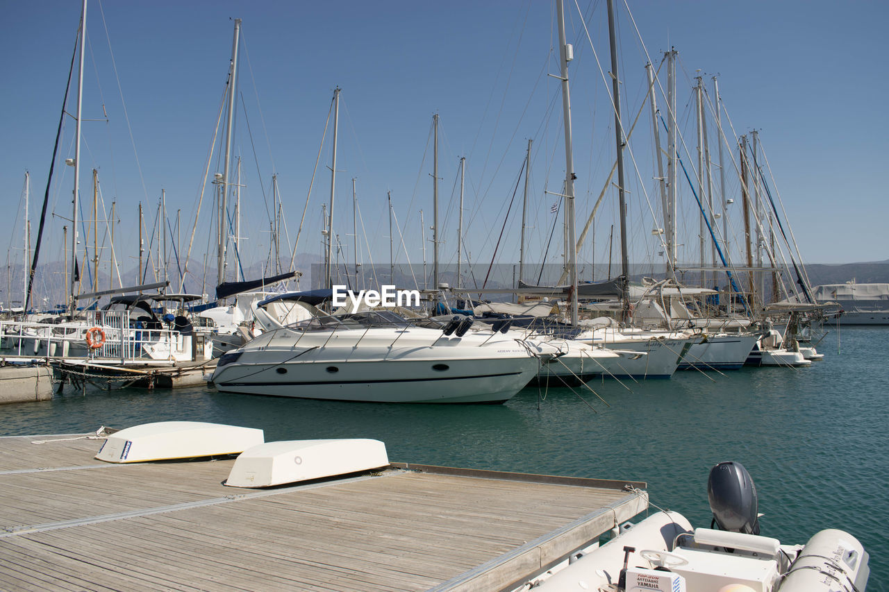 Sailboats moored on sea against sky