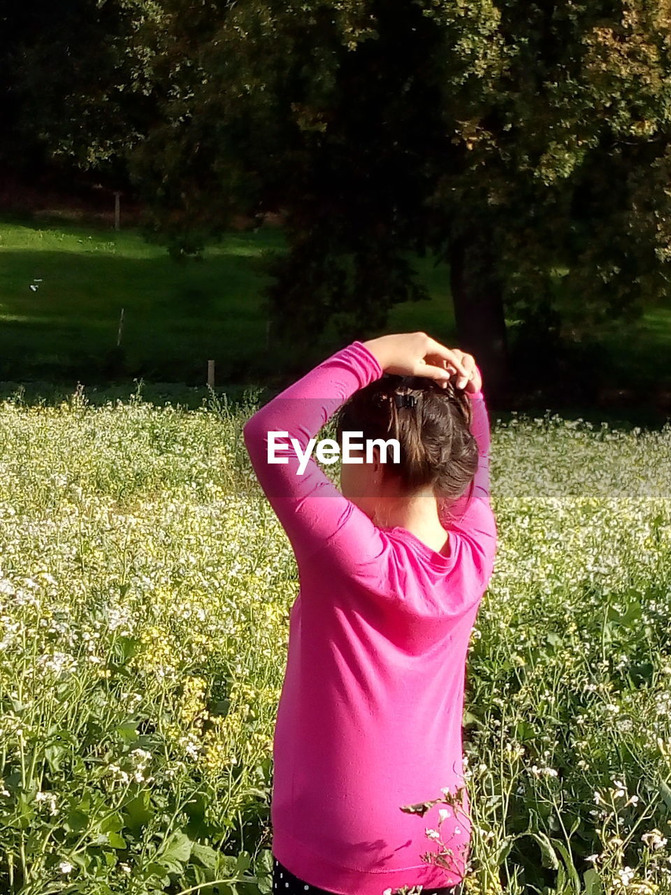 REAR VIEW OF WOMAN STANDING BY PINK FLOWERS