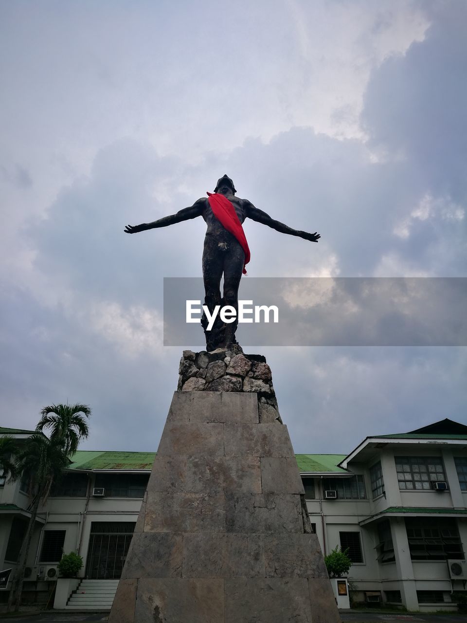 LOW ANGLE VIEW OF STATUE IN CITY AGAINST CLOUDY SKY