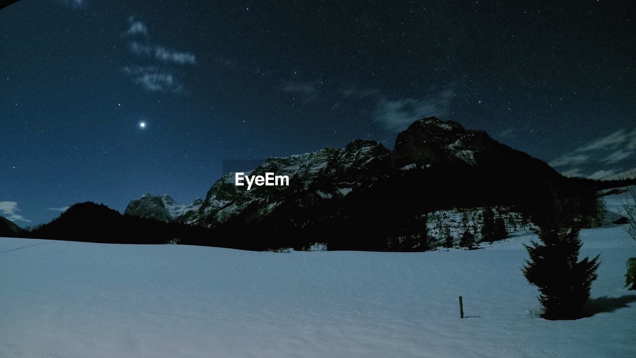 SCENIC VIEW OF SNOW COVERED MOUNTAINS AGAINST SKY