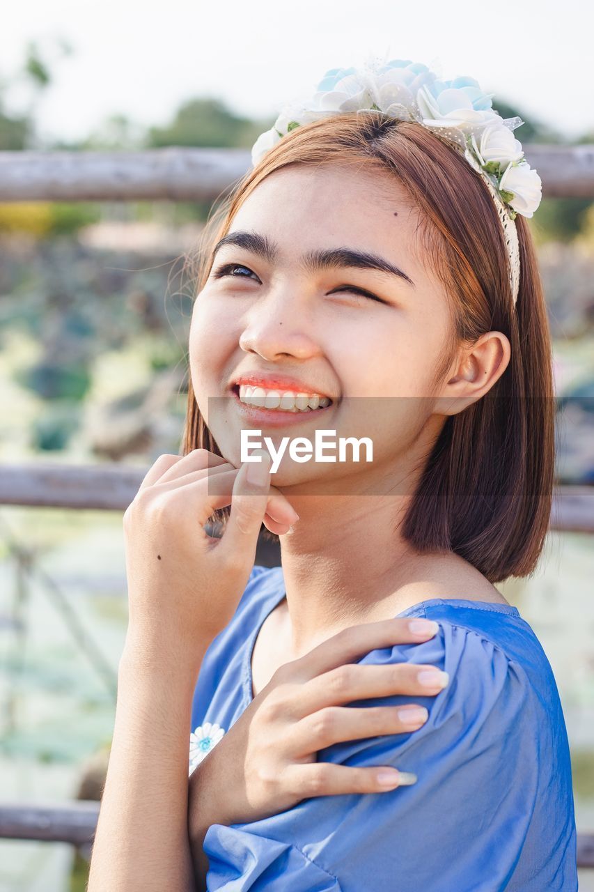 Portrait of asian woman smiling happy on sunny summer or spring day outside in park by river.