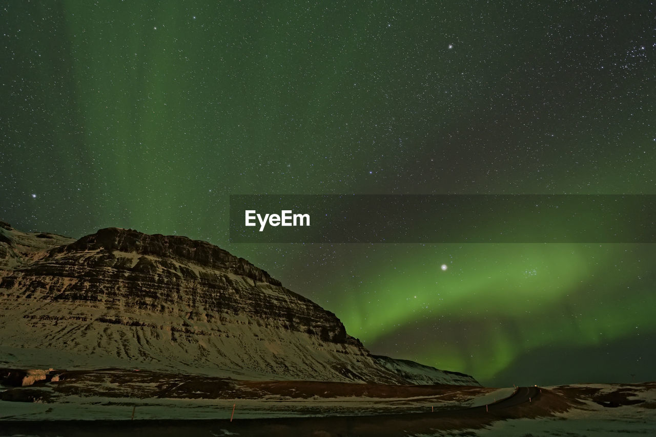 Low angle view of aurora borealis at night during winter