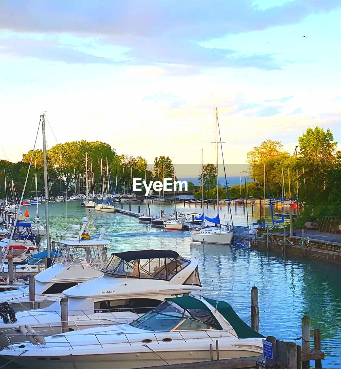 BOATS MOORED IN LAKE AGAINST SKY