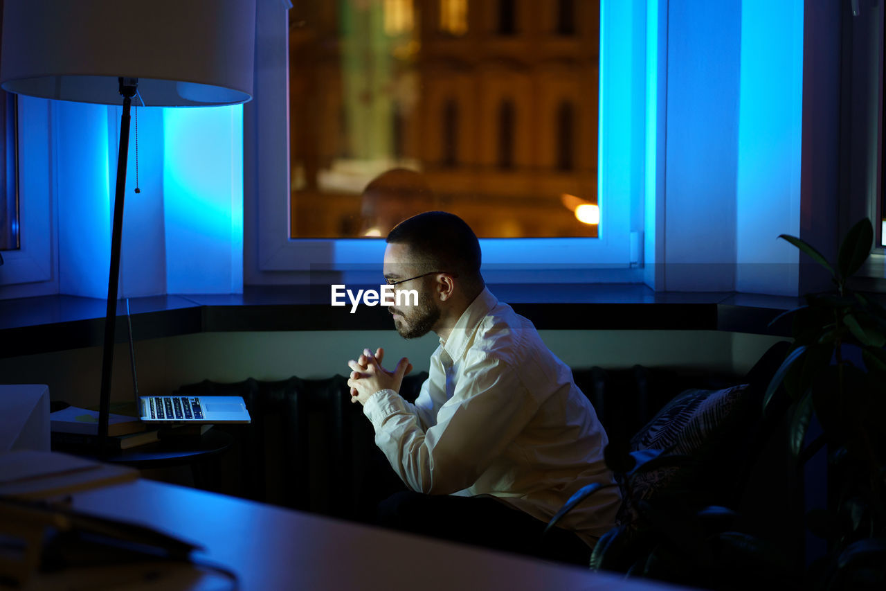 Thoughtful young businessman look at laptop monitor analyze financial report and sales late at night