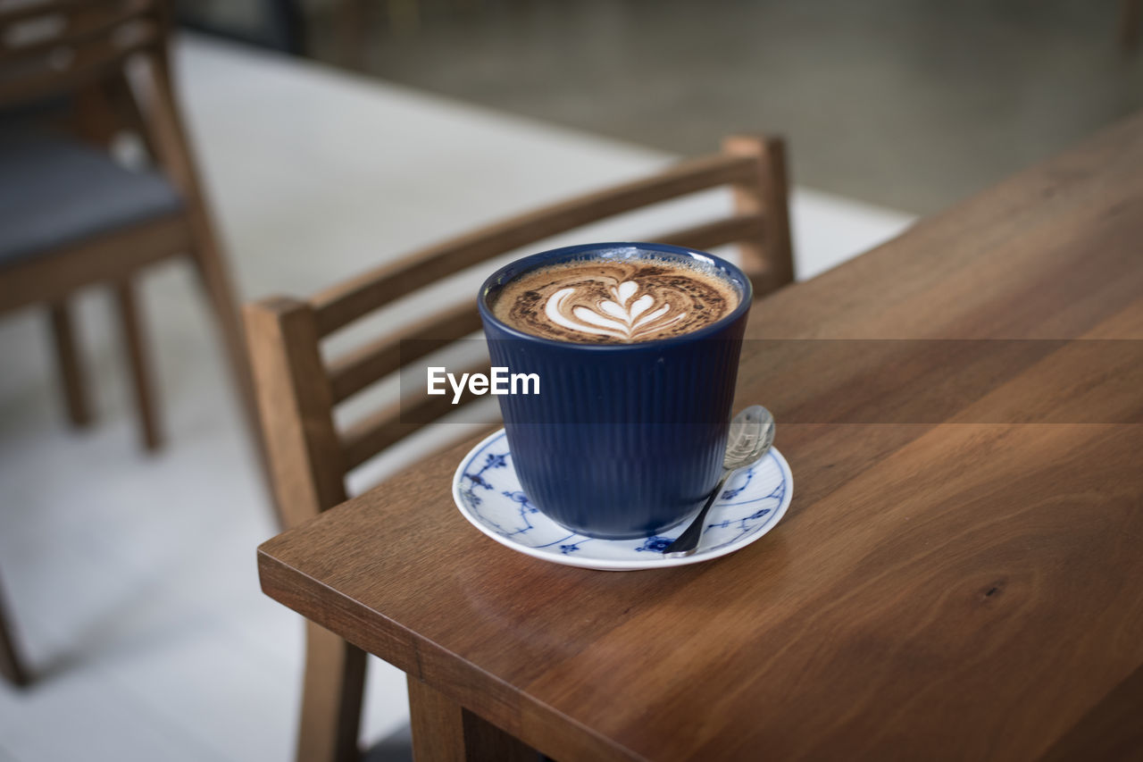 Close-up of coffee cup on wooden table