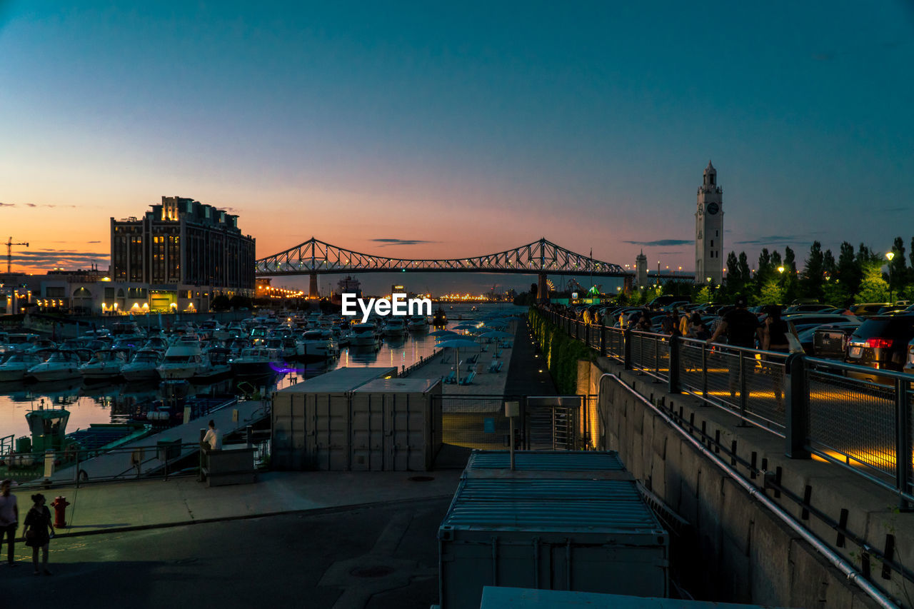 Bridge over river in city at dusk