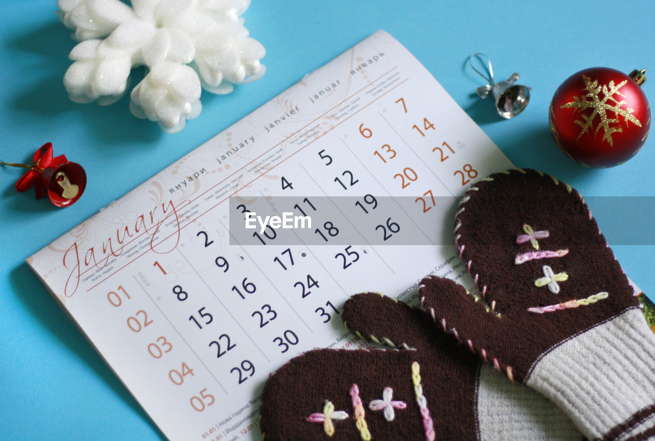 High angle view of calendar, winter gloves, christmas decoration