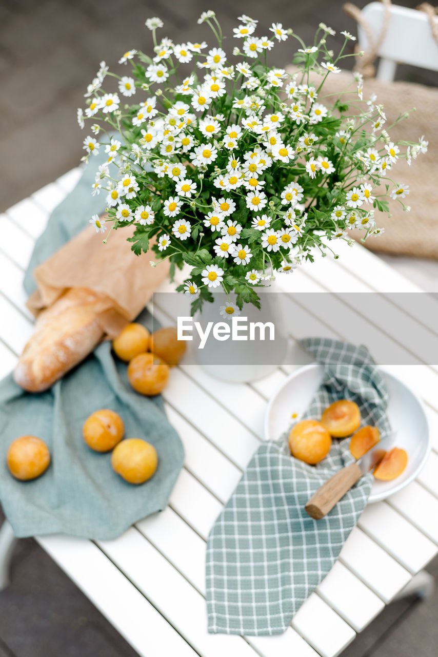 food and drink, food, plant, freshness, flower, flowering plant, healthy eating, yellow, nature, no people, wellbeing, table, fruit, high angle view, citrus fruit, orange color, indoors, produce, clementine, citrus, tangerine, orange, calamondin, vegetable, arrangement, day