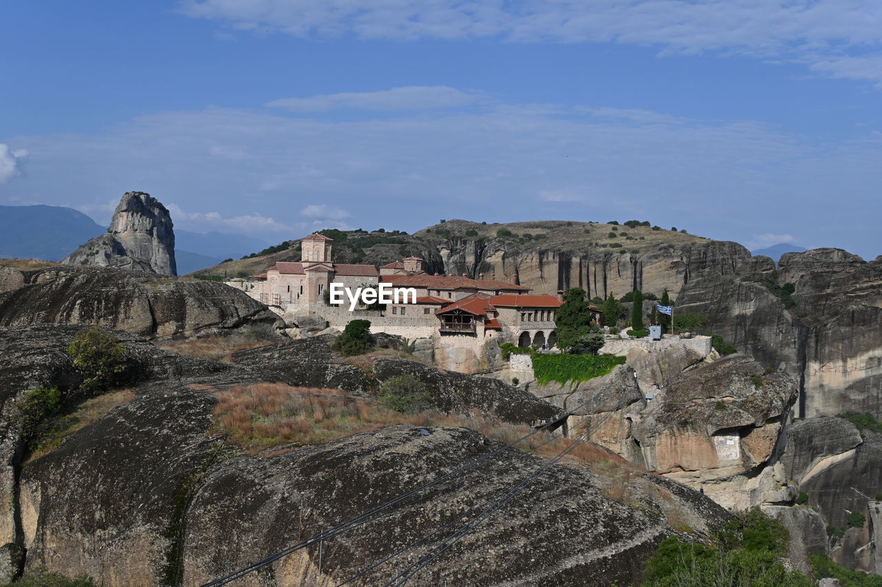 architecture, built structure, building exterior, sky, travel destinations, building, history, ruins, nature, the past, travel, mountain, cliff, ancient history, rock, fortification, vacation, terrain, land, tourism, town, no people, city, outdoors, landscape, cloud, ancient, day, environment, scenics - nature, house, sea, landmark, mountain range, village, castle, plant, blue, residential district, religion, coast, fort, beauty in nature