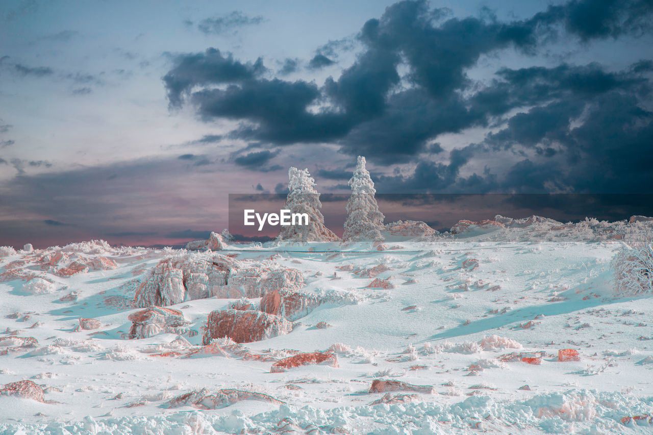 Scenic view of snowcapped mountains against sky during sunset