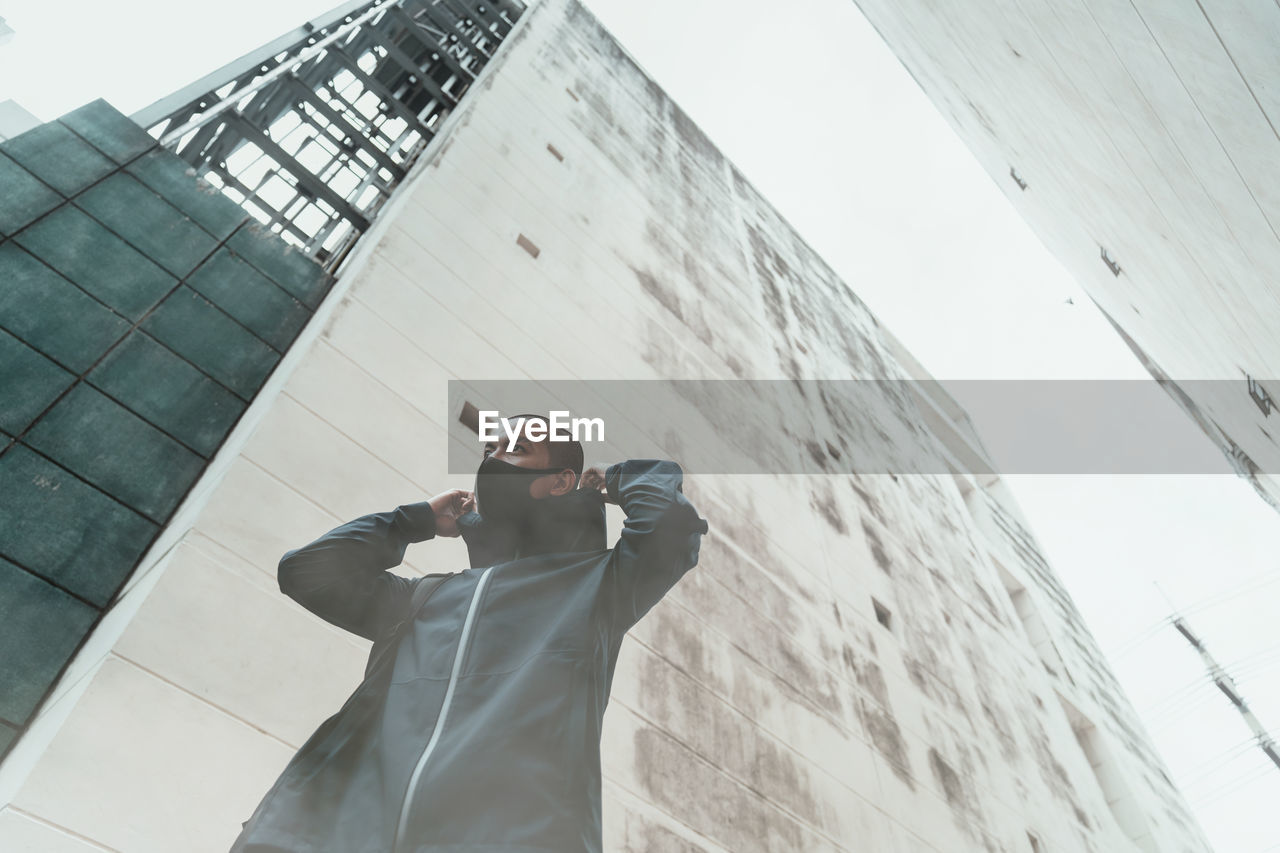 Low angle view of man standing by building