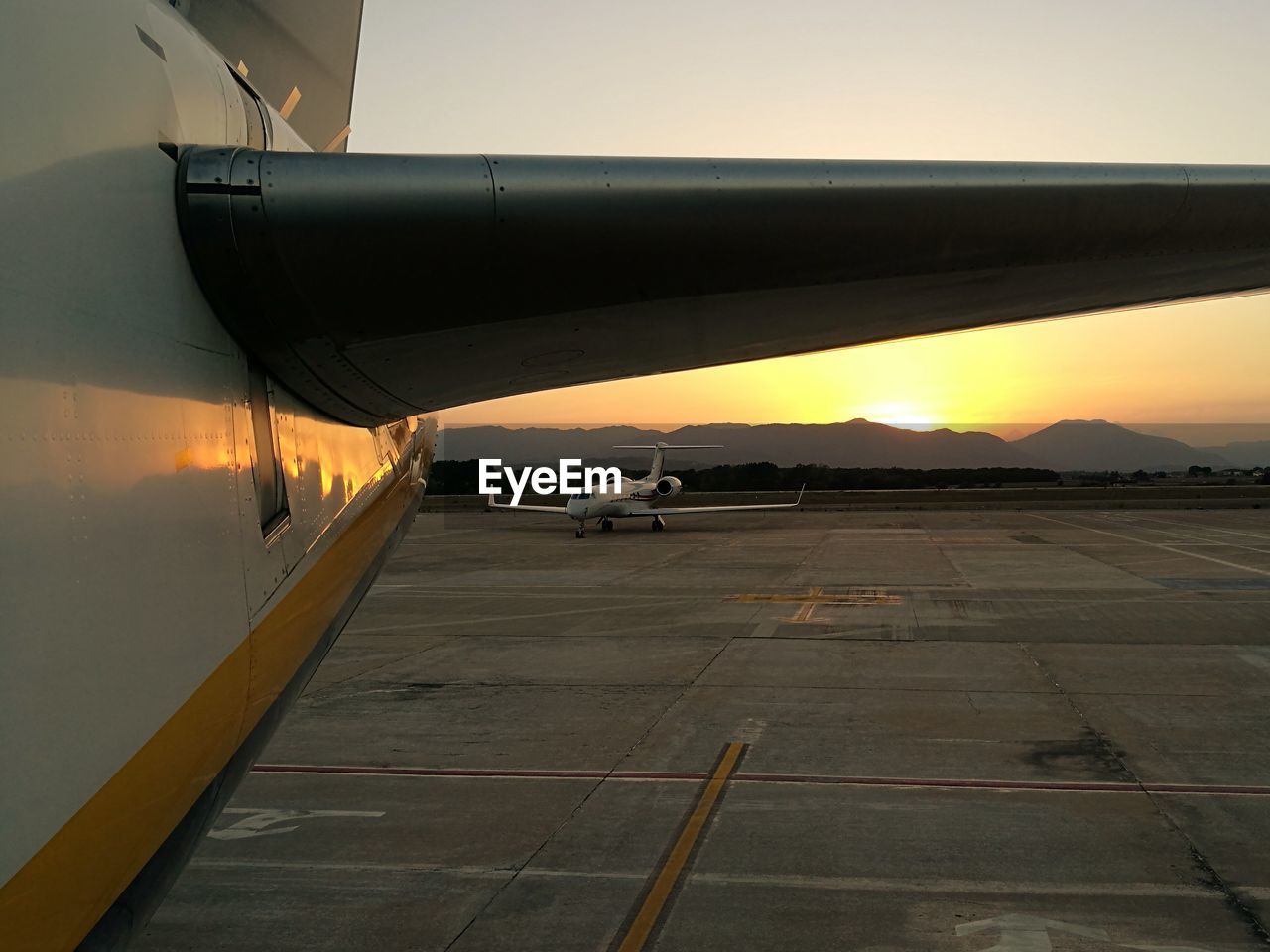 AIRPLANE ON AIRPORT RUNWAY AGAINST SKY