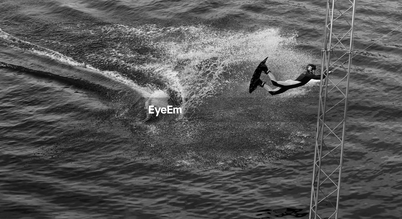 Man enjoying kiteboarding on platform in sea