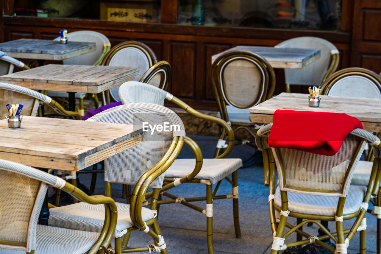 EMPTY CHAIRS AND TABLE AT CAFE