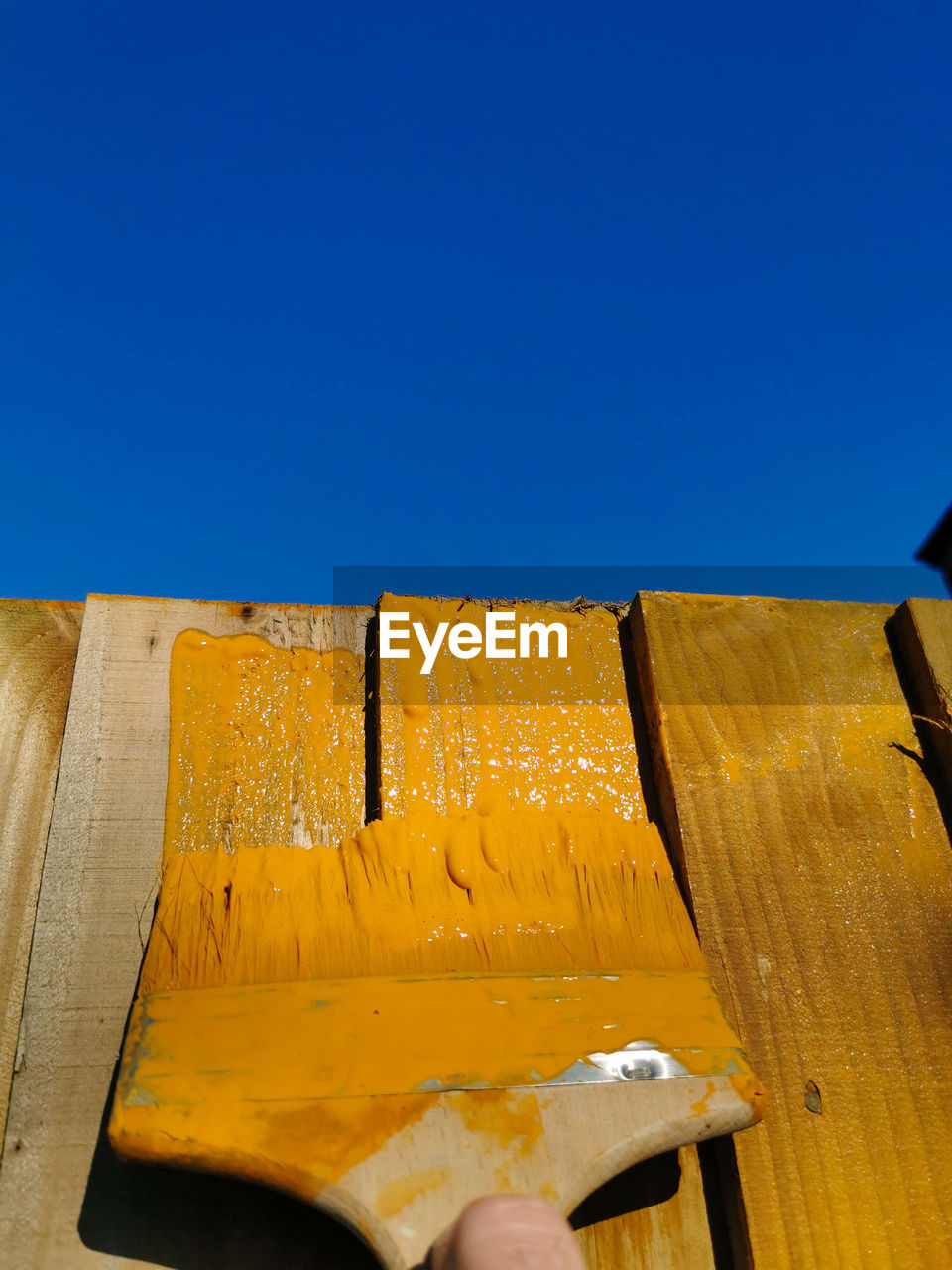 yellow, blue, sky, wood, clear sky, nature, day, copy space, architecture, wall, one person, outdoors, sunny, low angle view, sunlight