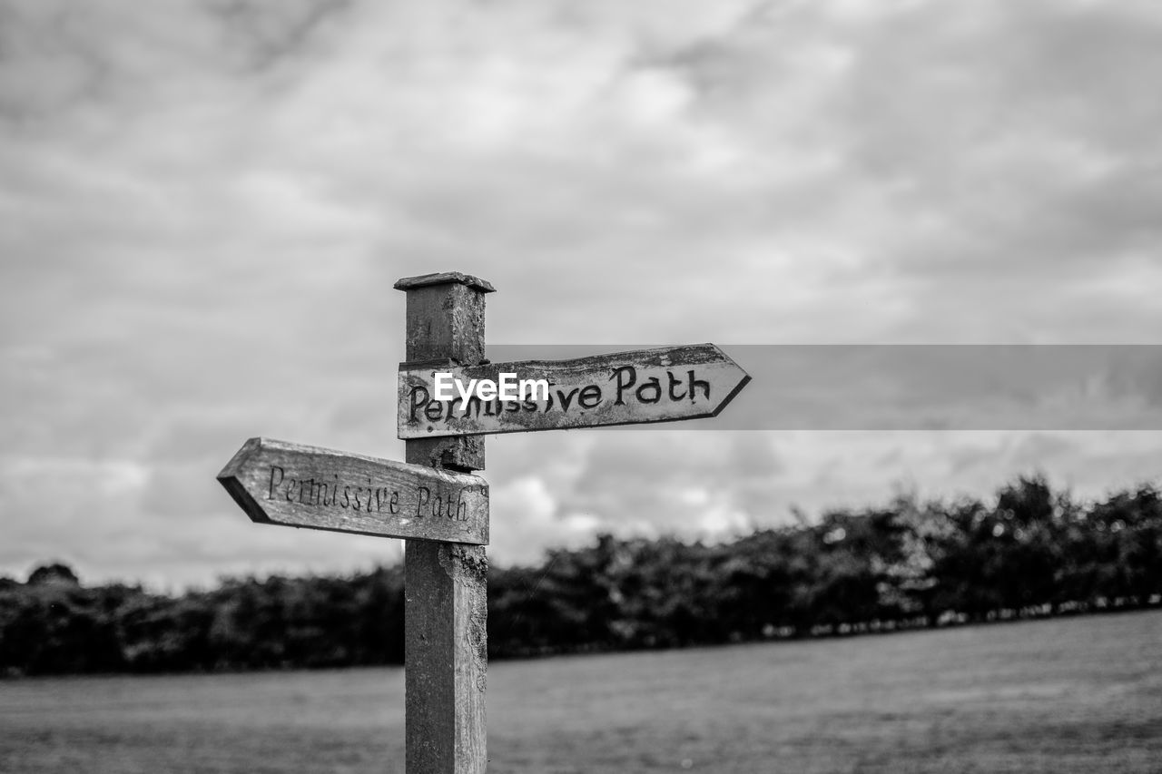 Information sign against cloudy sky