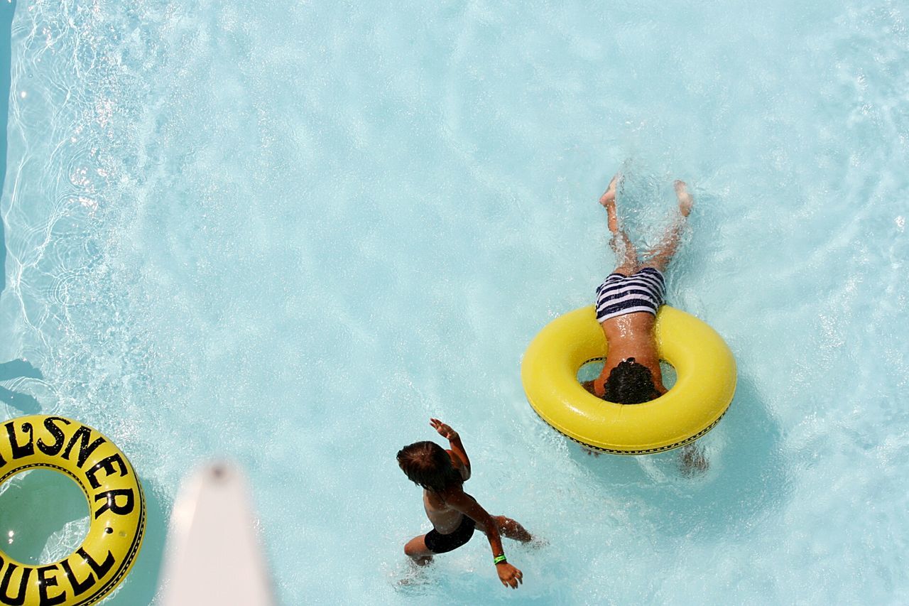 HIGH ANGLE VIEW OF BABY SWIMMING IN POOL