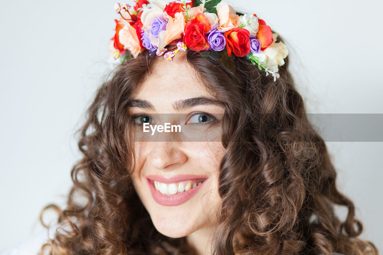 Close-up portrait of smiling woman wearing floral wreath