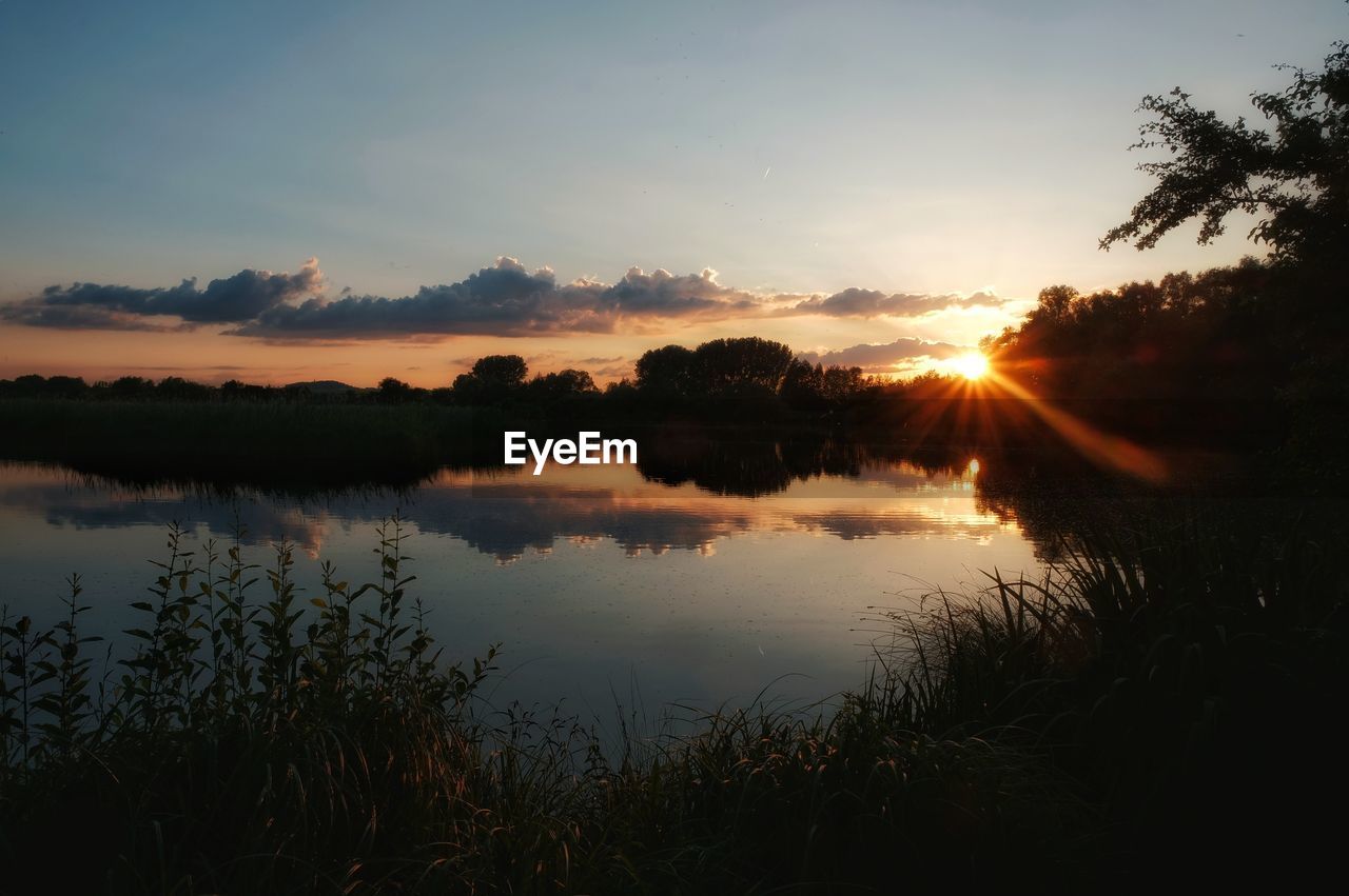 SCENIC VIEW OF LAKE AGAINST ORANGE SKY