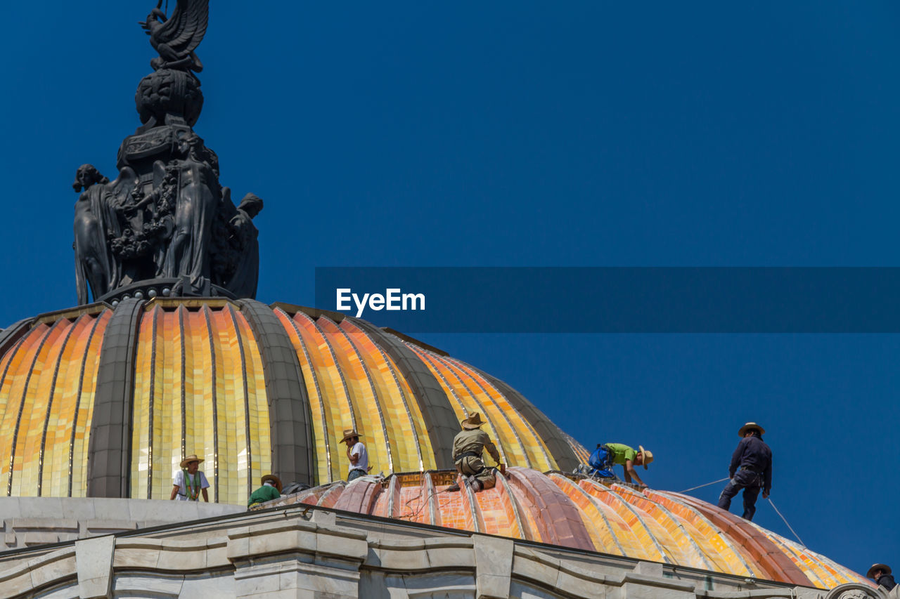 LOW ANGLE VIEW OF STATUES AGAINST CLEAR BLUE SKY