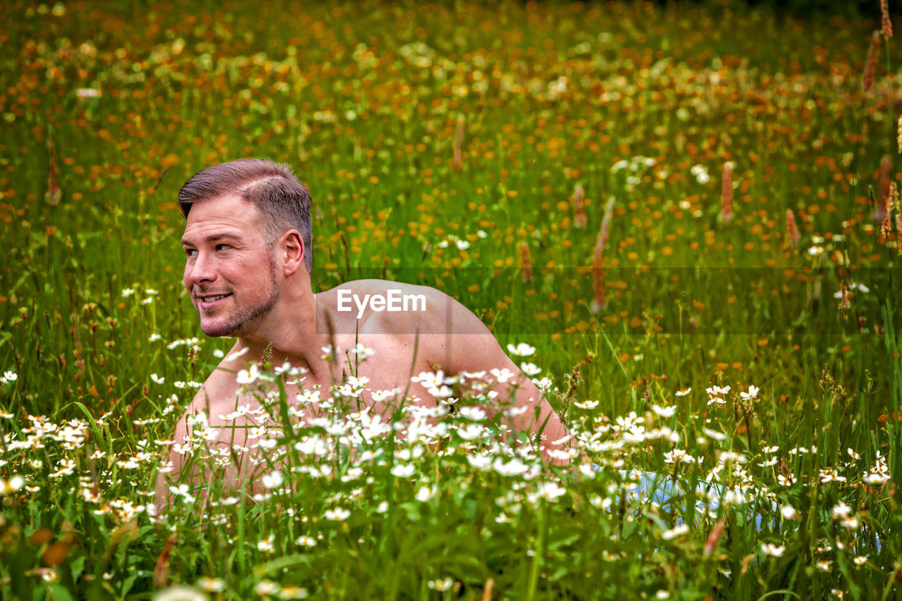 Shirtless man lying on field