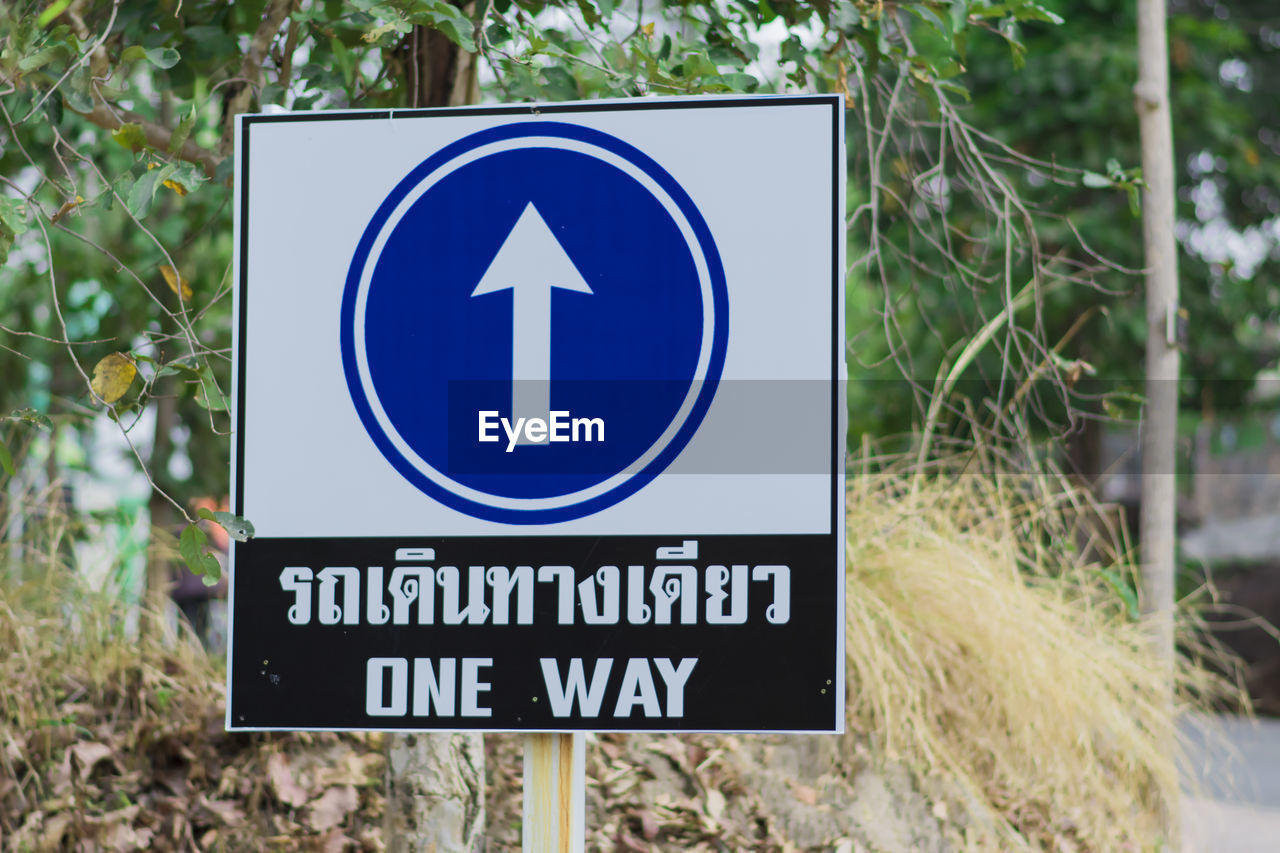 CLOSE-UP OF ROAD SIGN AGAINST BLUE WALL