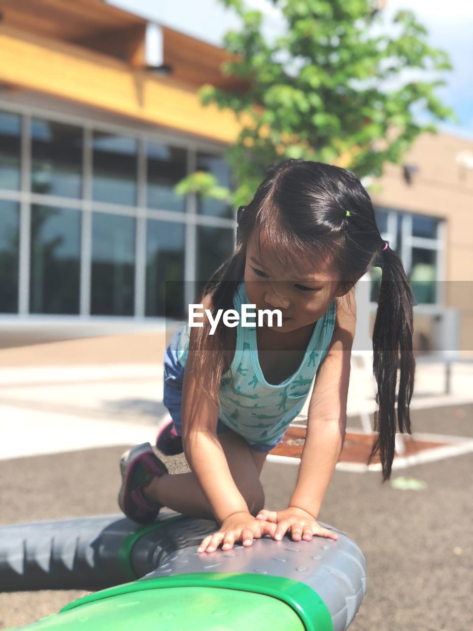 Girl kneeling on play equipment at playground