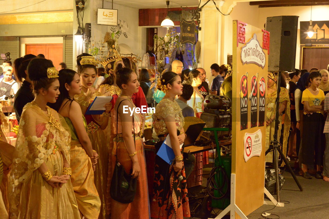 GROUP OF PEOPLE STANDING IN FRONT OF TRADITIONAL FESTIVAL