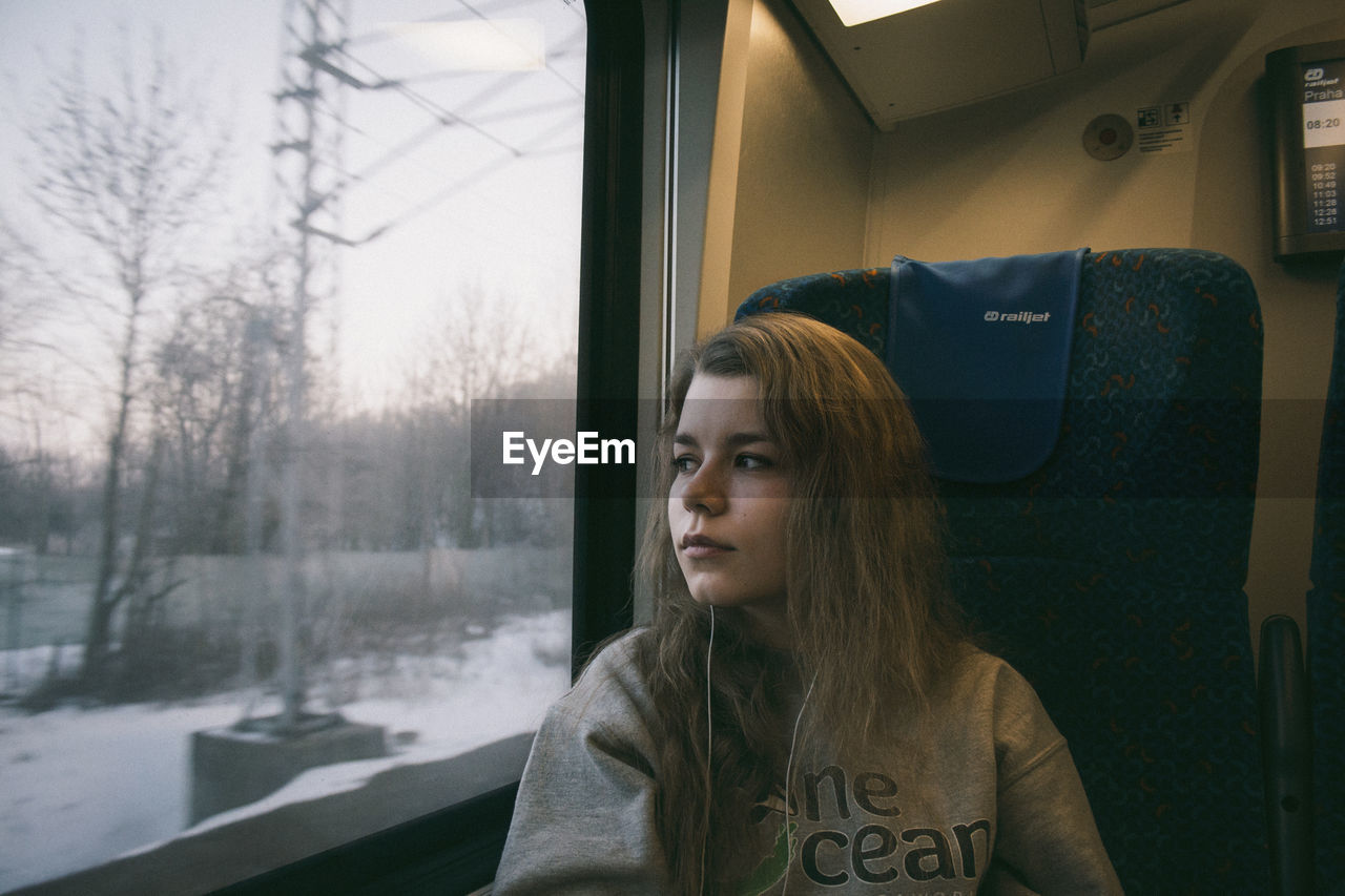 WOMAN LOOKING THROUGH WINDOW IN BUS