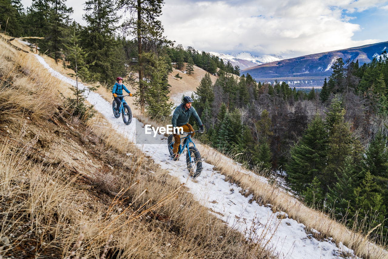 Couple fat biking winter trails in jasper national park
