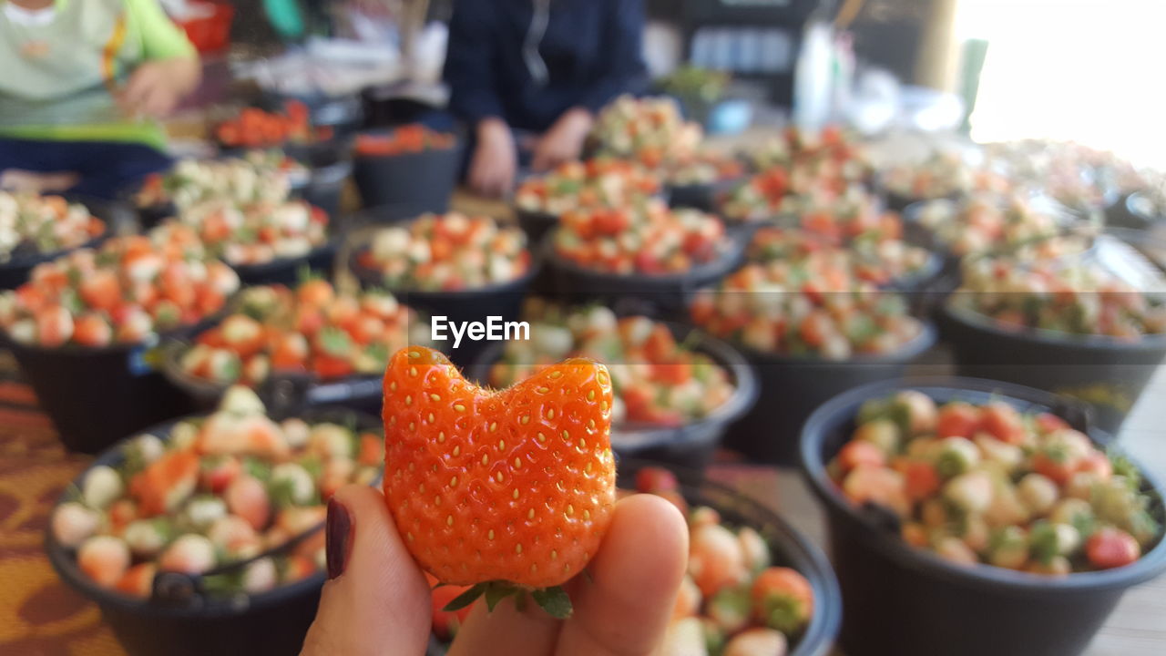 Close-up of hand holding strawberry at market