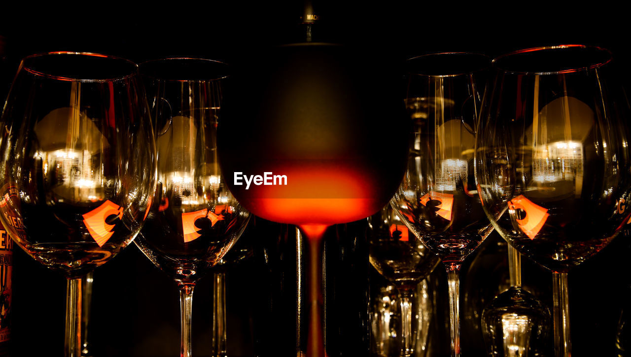 CLOSE-UP OF WINE BOTTLES AGAINST ILLUMINATED CANDLES