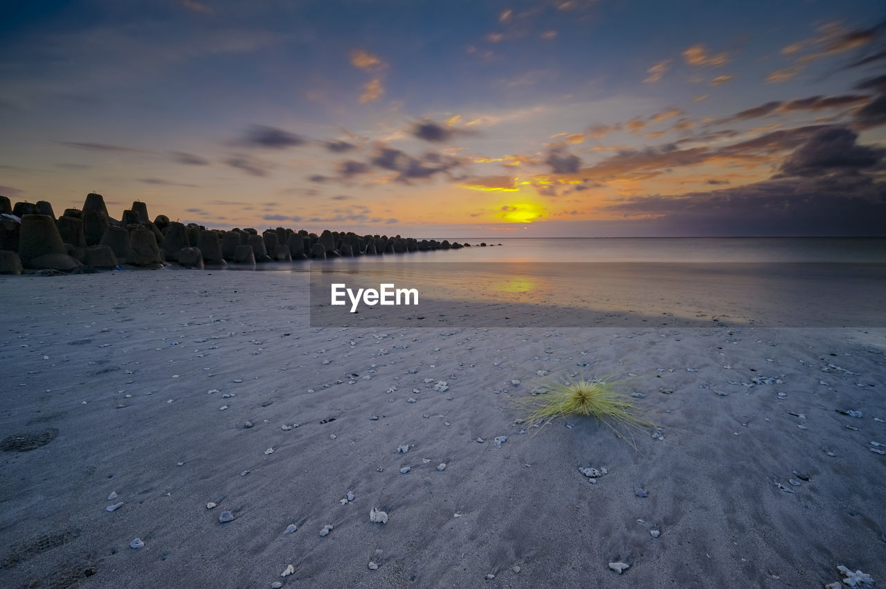 Scenic view of beach against sky during sunset