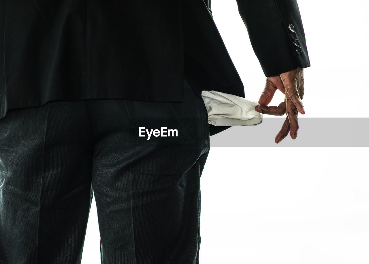 REAR VIEW OF MAN WITH ARMS OUTSTRETCHED AGAINST WHITE BACKGROUND