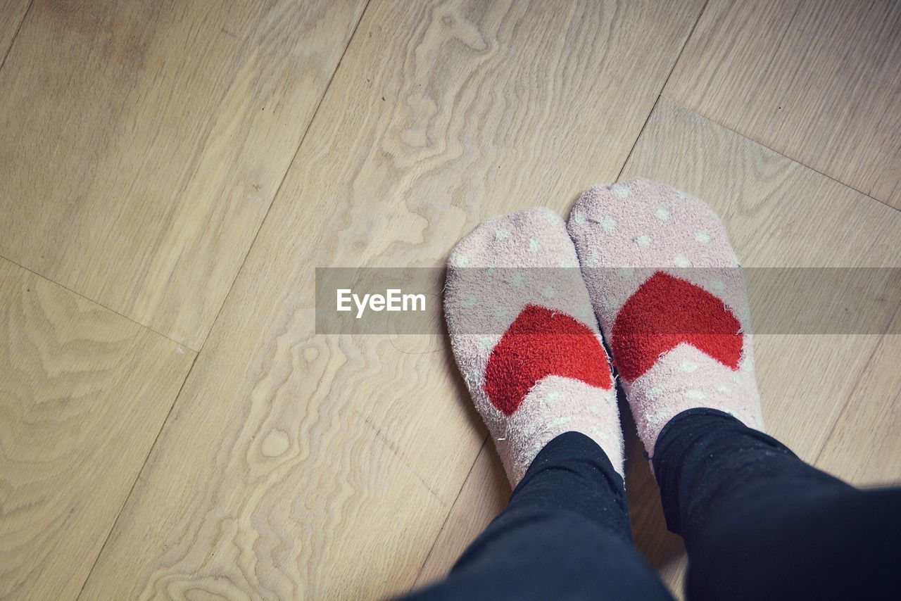 LOW SECTION OF PERSON STANDING ON TILED FLOOR