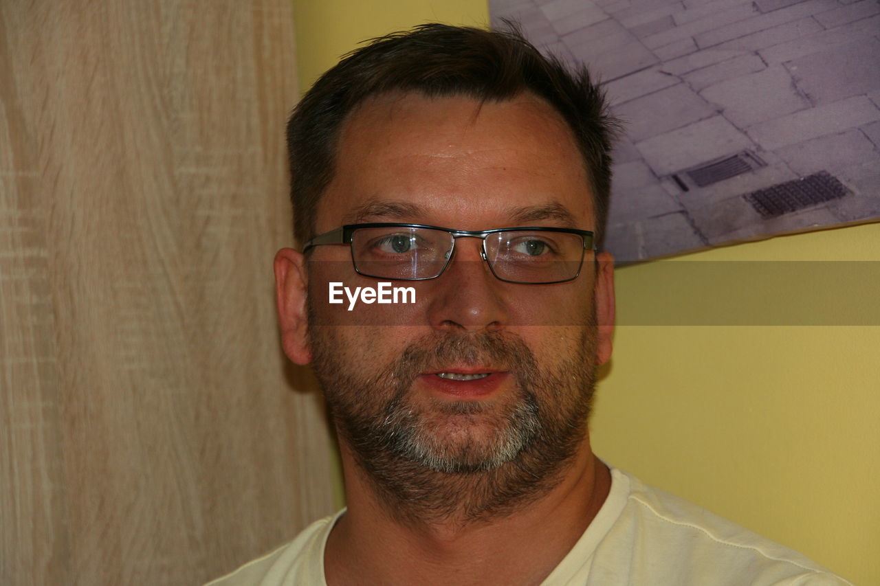 CLOSE-UP PORTRAIT OF SMILING MAN WITH EYEGLASSES