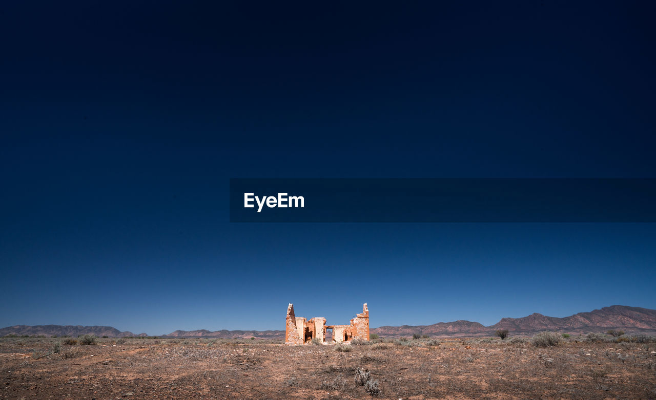 Ruined structure against clear blue sky