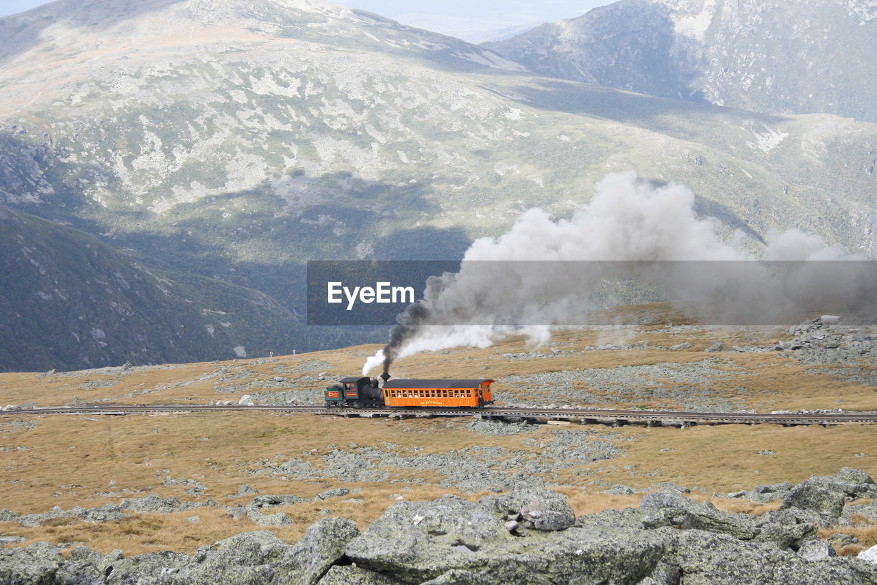 Steam train of mount washington cog railway pusing up coach to the summit at good weather conditions