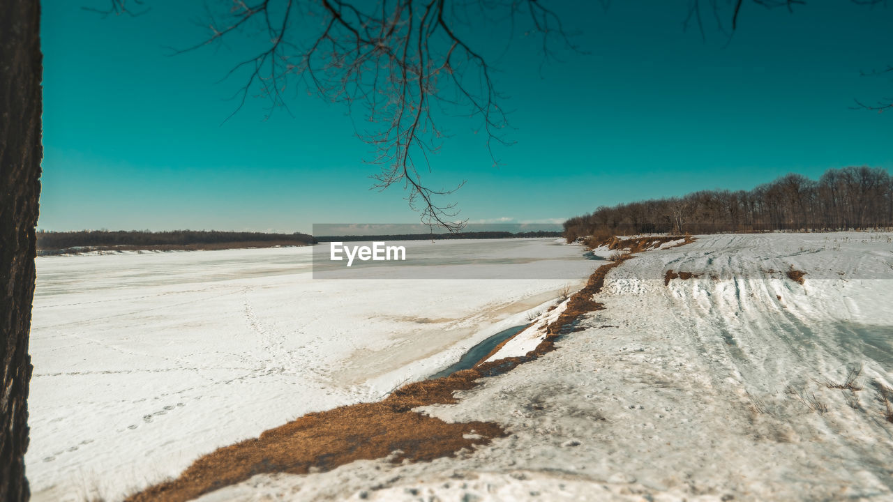 SCENIC VIEW OF SNOW COVERED LANDSCAPE AGAINST CLEAR BLUE SKY