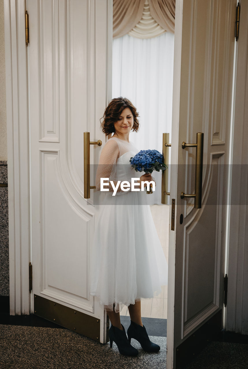 WOMAN STANDING BY DOOR OF HOME