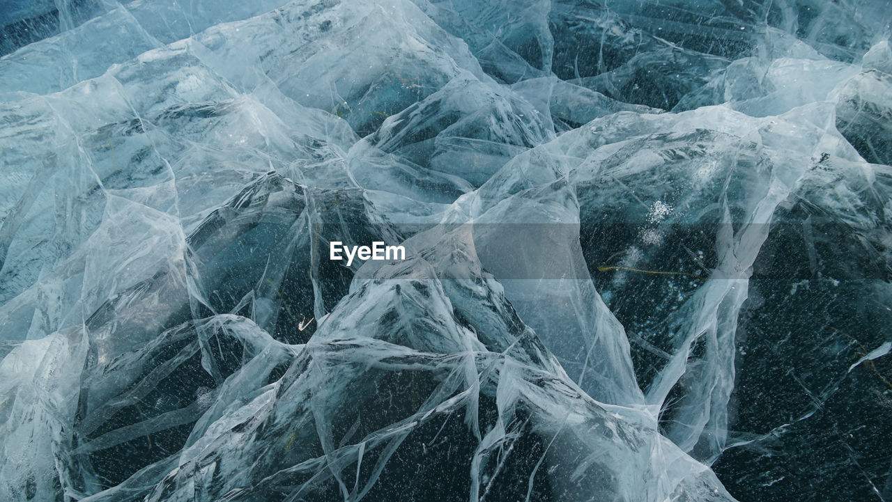 Transparent ice of lake baikal with a pattern of cracks