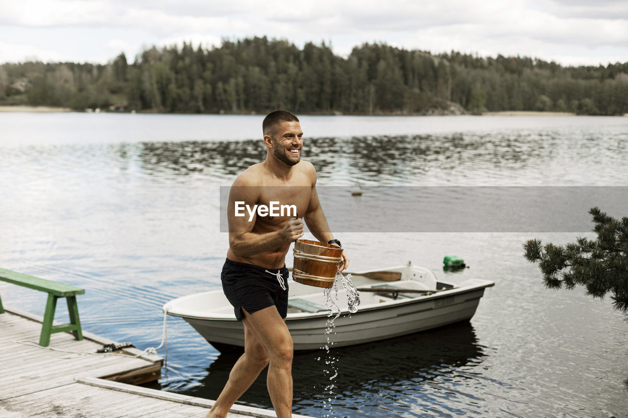 Man carrying bucket at lake