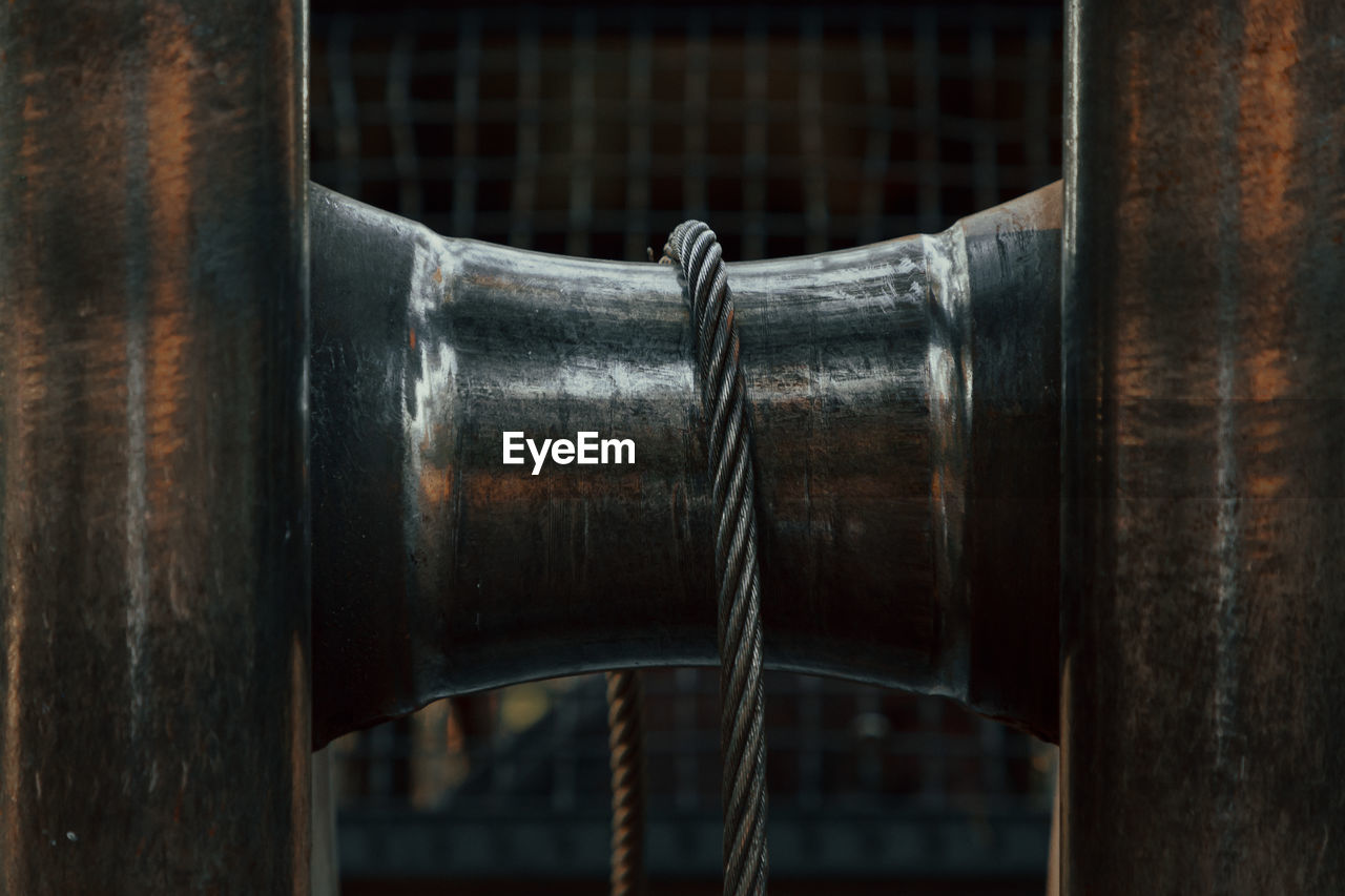 A close-up of a tractor winch. coil and metal chain.