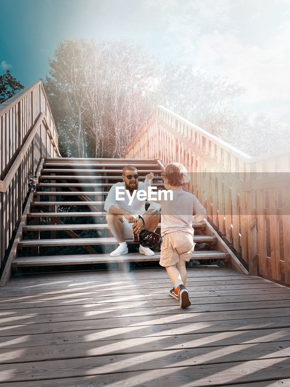 Full length of man and som on footbridge