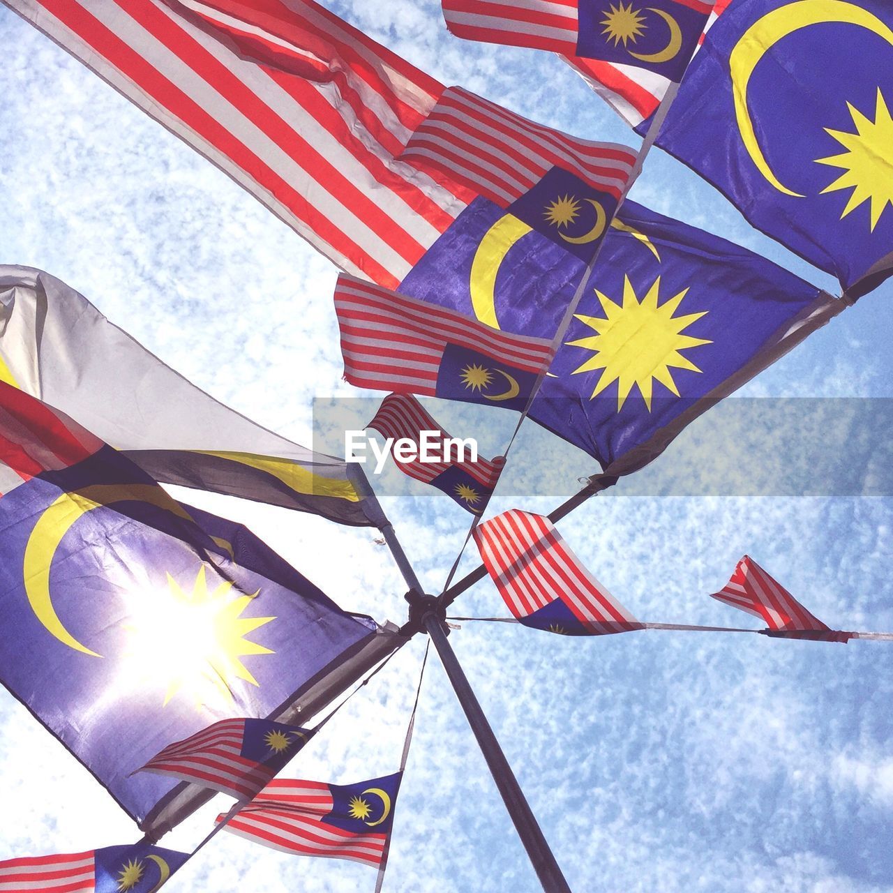 Low angle view of malaysian flags against sky