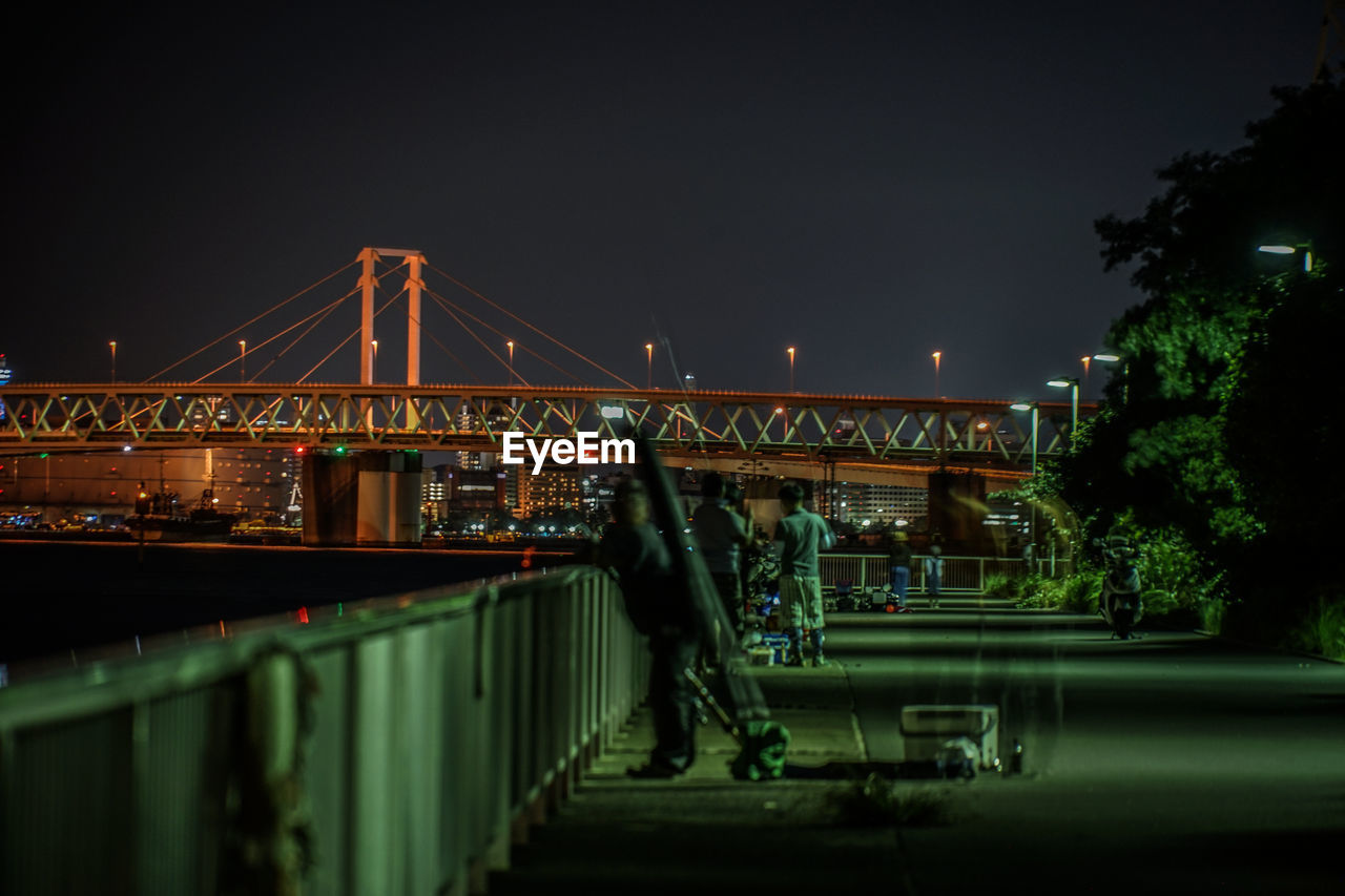 ILLUMINATED BRIDGE AGAINST SKY IN CITY AT NIGHT