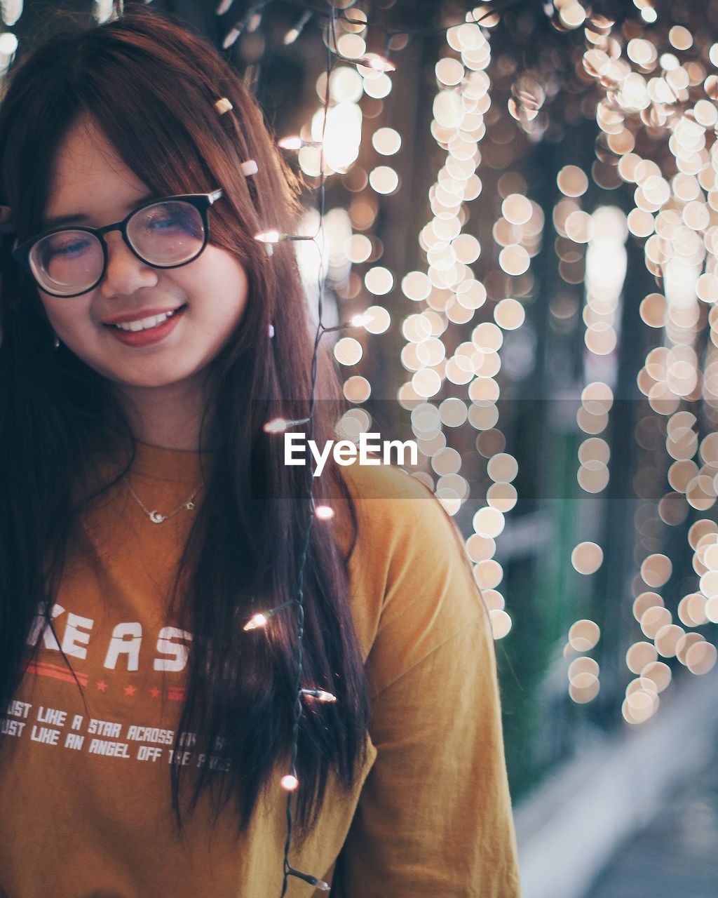 PORTRAIT OF A SMILING YOUNG WOMAN WEARING EYEGLASSES