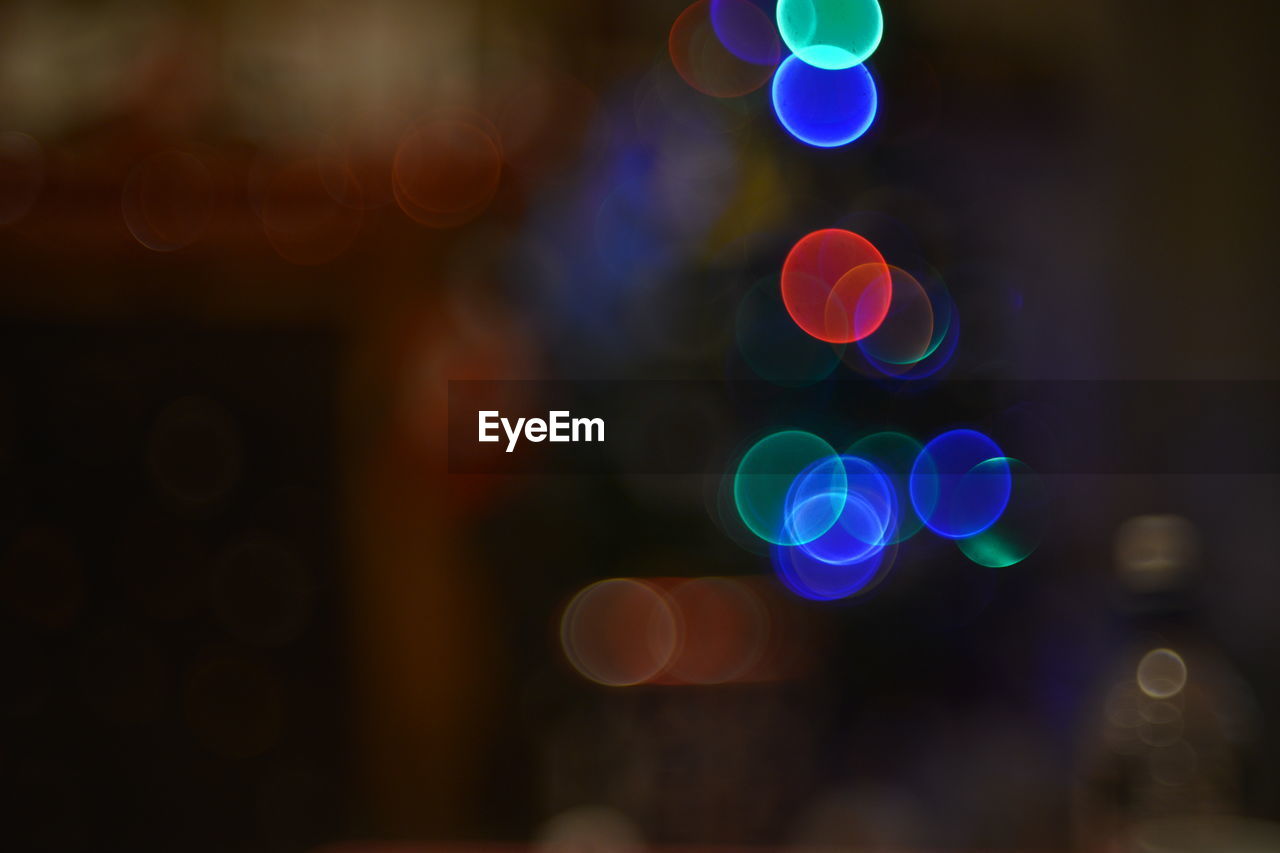 Defocused image of illuminated colorful lighting equipment at night