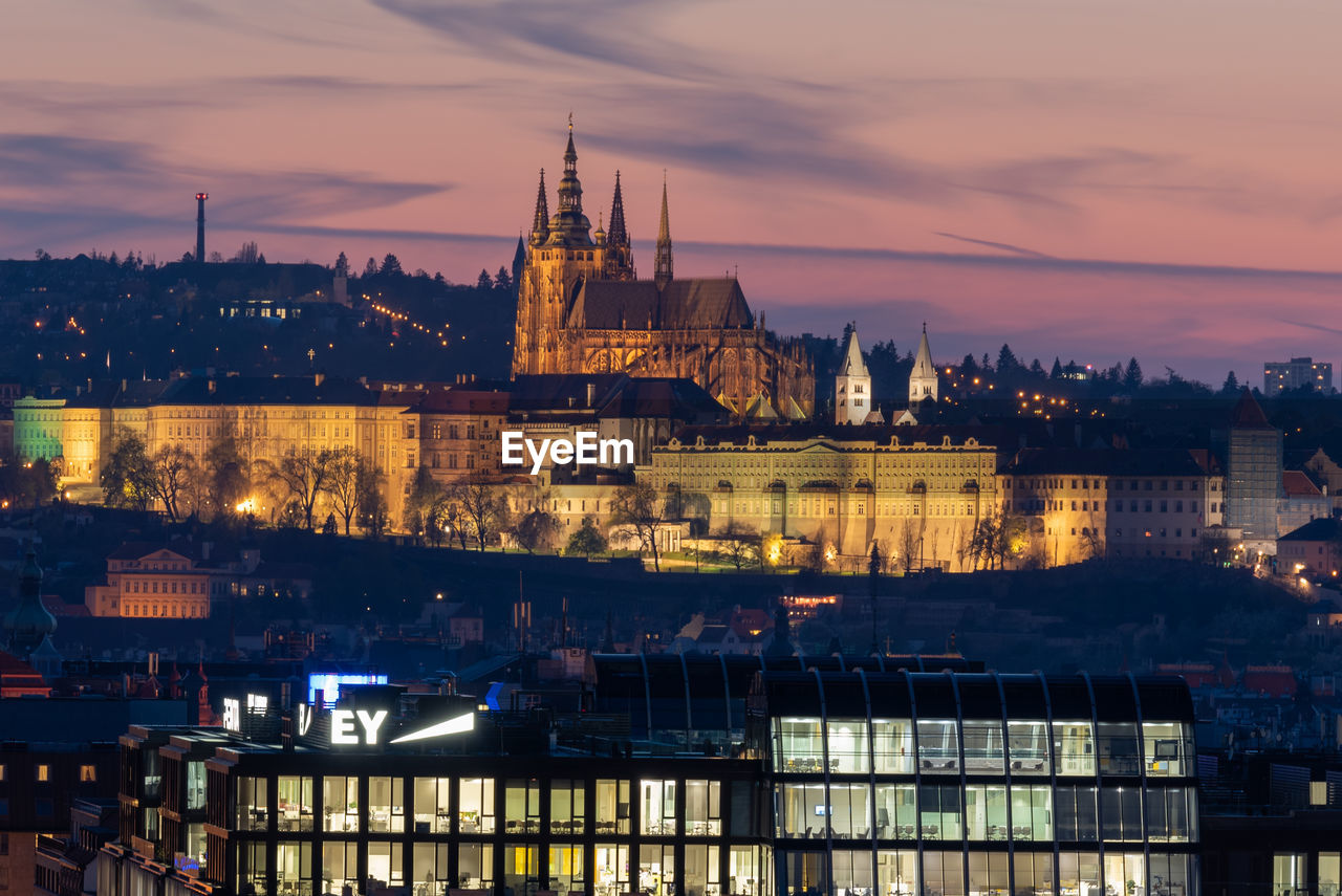 Illuminated buildings in city at dusk