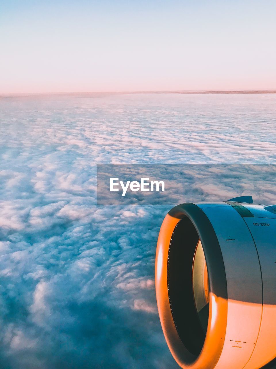 AIRPLANE FLYING OVER SEA DURING SUNSET